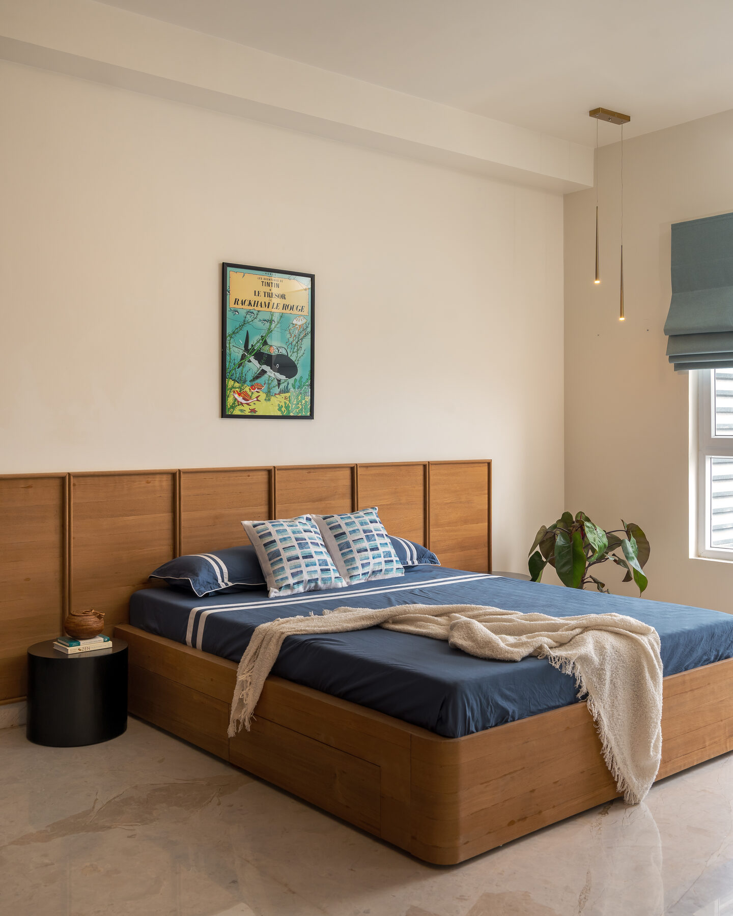 Bedroom with walnut panelled bed and navy linen