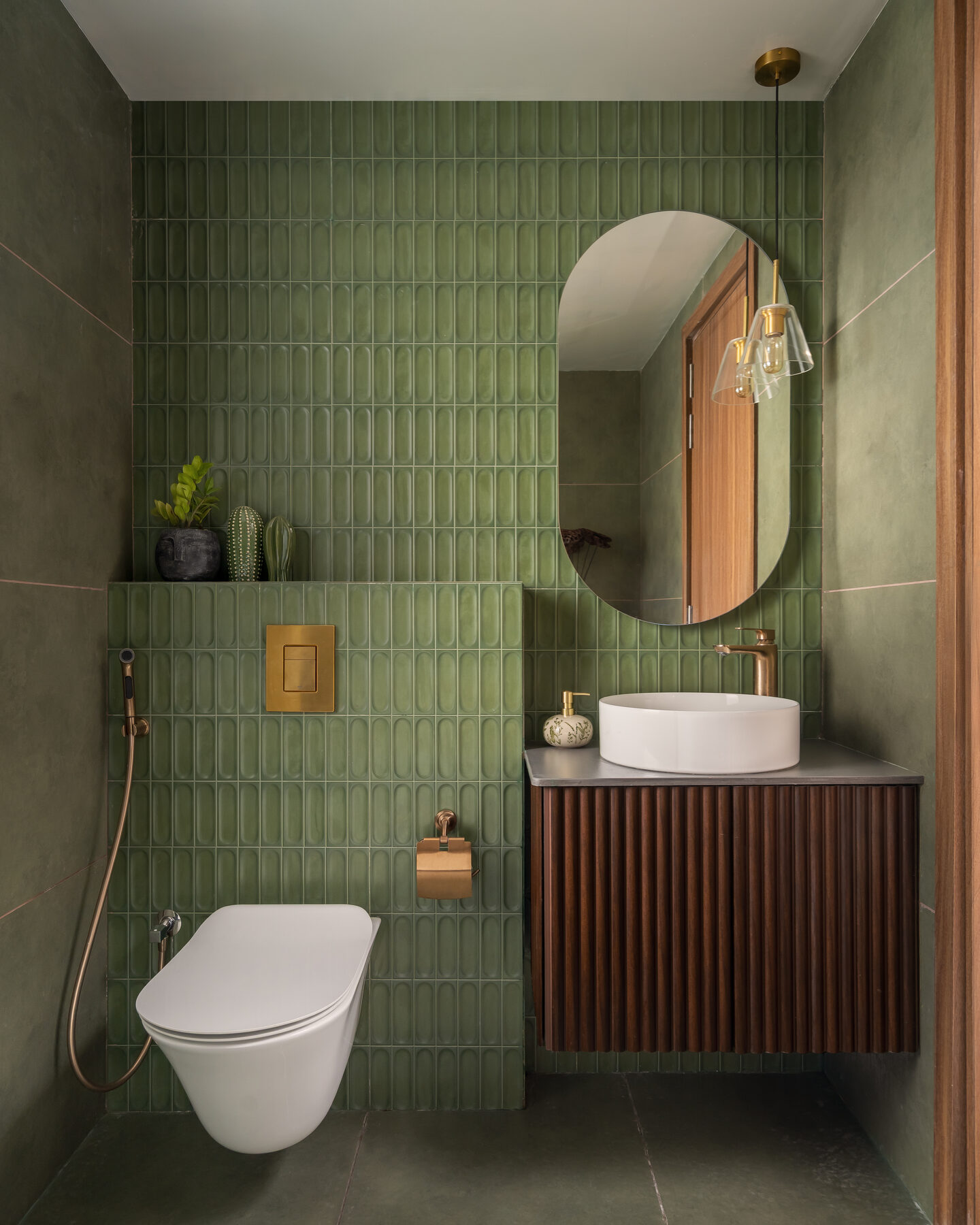 Powder room with fluted green tile and brass fittings